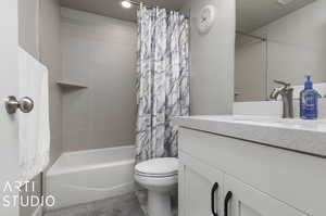 Full bathroom with tile patterned flooring, shower / bath combo, toilet, and vanity