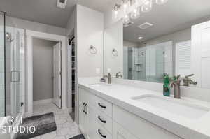 Primary Bathroom with dual vanity, a shower with shower door, and tile patterned flooring