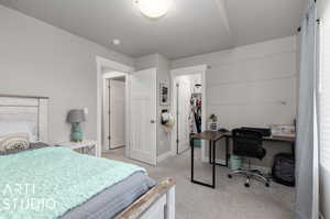 Bedroom with light carpet, a closet, and a walk in closet