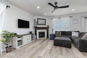 Living room with light hardwood / wood-style floors and ceiling fan