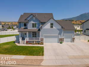 View of front of property featuring a garage, a porch, a mountain view, and a front yard