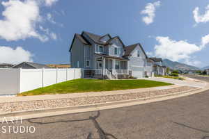 View of front of home with a garage, a front lawn, and a mountain view