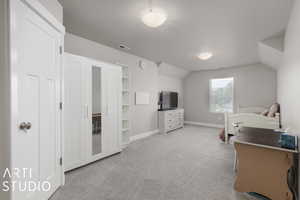 Carpeted bedroom featuring lofted ceiling