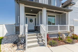 View of exterior entry featuring covered porch