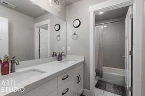 Bathroom with tile patterned floors, dual bowl vanity, and shower / bath combination with curtain