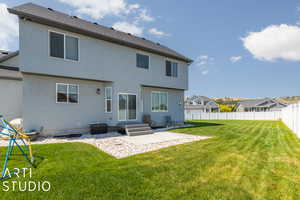 Rear view of house with a patio area and a lawn