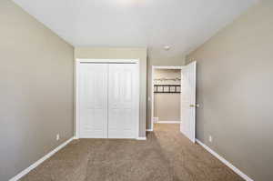 Unfurnished bedroom featuring a closet, carpet floors, and a textured ceiling