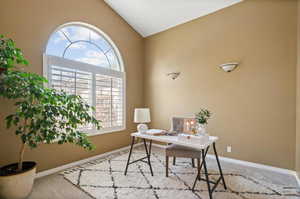 Carpeted office space featuring lofted ceiling and plenty of natural light