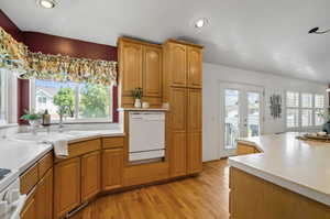 Kitchen with dishwasher, light hardwood / wood-style floors, stove, and sink