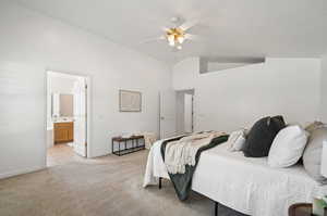 Carpeted bedroom featuring lofted ceiling, ceiling fan, and connected bathroom