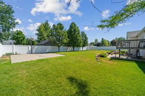 View of yard with a wooden deck and a patio area