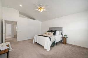 Carpeted bedroom with high vaulted ceiling and ceiling fan