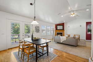 Dining area with light hardwood / wood-style floors, vaulted ceiling, french doors, and ceiling fan