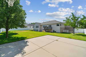 View of front of home with a patio, a wooden deck, and a front lawn