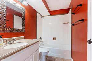 Full bathroom featuring tile patterned flooring, bathing tub / shower combination, toilet, and vanity