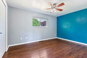 Spare room featuring dark hardwood / wood-style floors and ceiling fan