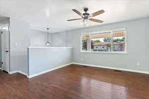 Unfurnished room with ceiling fan and dark wood-type flooring