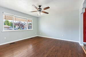 Spare room featuring dark hardwood / wood-style floors and ceiling fan