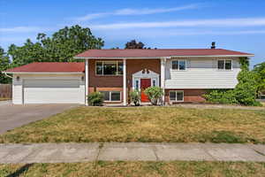 Raised ranch with a garage and a front yard