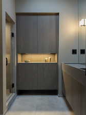 Bathroom featuring an enclosed shower, tasteful backsplash, and concrete floors