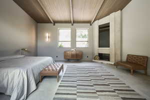 Bedroom featuring wood ceiling, a fireplace, carpet floors, and vaulted ceiling with beams