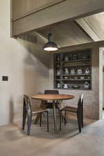 Dining room featuring wood ceiling, built in shelves, and concrete flooring