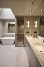 Bathroom with tile patterned floors, separate shower and tub, tile walls, and double vanity