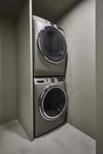 Laundry area featuring carpet and stacked washer and dryer