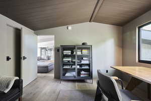 Office area featuring wood-type flooring and lofted ceiling with beams