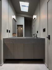 Bathroom featuring a skylight, vanity, tile patterned floors, and elevator