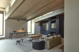 Carpeted living room with beamed ceiling, a fireplace, plenty of natural light, and wood ceiling