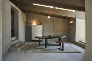 Dining room with concrete flooring, lofted ceiling with beams, and wood ceiling