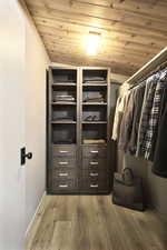 Walk in closet featuring vaulted ceiling and hardwood / wood-style floors