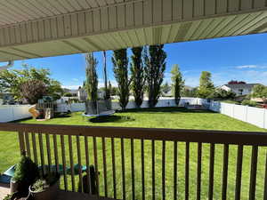 Relaxing covered deck with views of mature trees and swing set / play area