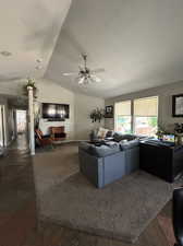 Spacious great room / living room with ceiling fan and lofted ceiling