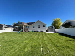 Expansive, fully fenced backyard featuring large covered deck, patio area and shed with power