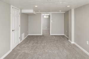 Basement with carpet floors and a textured ceiling