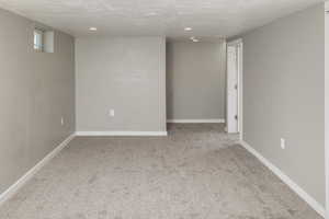 Spare room featuring a textured ceiling and carpet flooring