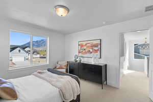 Carpeted bedroom featuring multiple windows and a chandelier