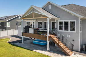 Back of property featuring central air condition unit and a yard