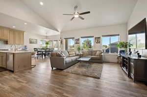 Living room with high vaulted ceiling, a wealth of natural light, ceiling fan, and hardwood / wood-style floors