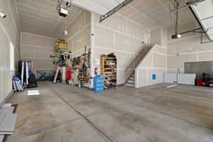 Garage featuring a garage door opener and fridge