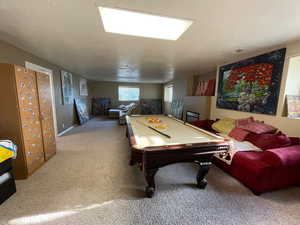 Playroom featuring pool table, a textured ceiling, and carpet flooring