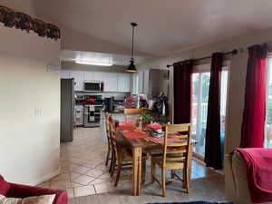 Tiled dining room with vaulted ceiling