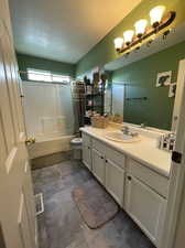 Full bathroom with shower / bath combo, toilet, tile patterned floors, and vanity