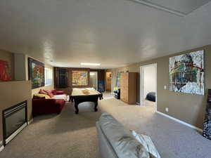 Playroom with a textured ceiling, carpet, and pool table