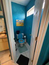 Bathroom featuring vanity, toilet, and tile patterned flooring