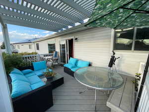 Deck with a pergola and an outdoor living space