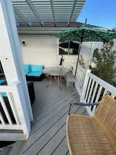 Wooden deck featuring a pergola and an outdoor living space