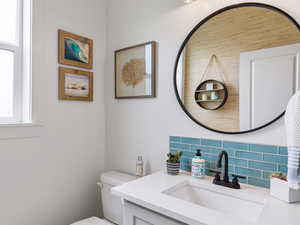 Half bath on main with subway tile backsplash.